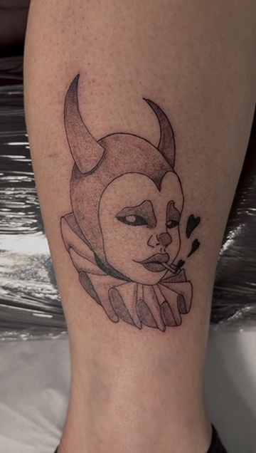 Tatouage en noir représentant un personnage aux cornes